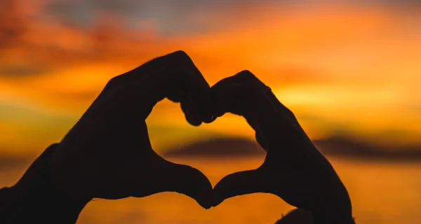 couple-making-heart-from-hands-sea-shore