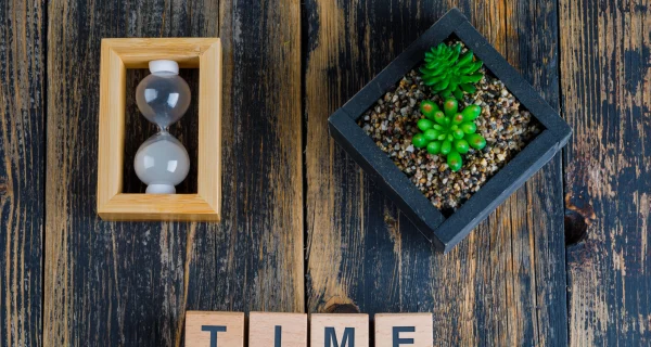 business-concept-with-time-word-wooden-cubes-hourglass-plant